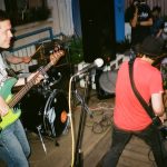 two men playing electric guitars